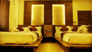 Habitación de hotel con dos camas, cabeceros de madera y un pasillo central.