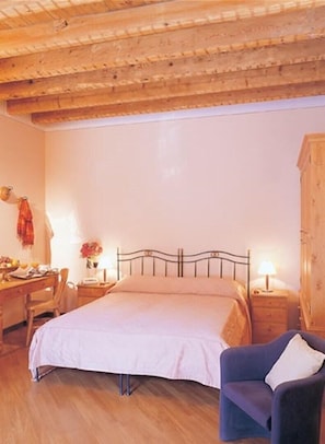 A bedroom with a bed, a desk with a chair, a wardrobe, and a nightstand with a lamp. - Hotel Pace (Sirmione)