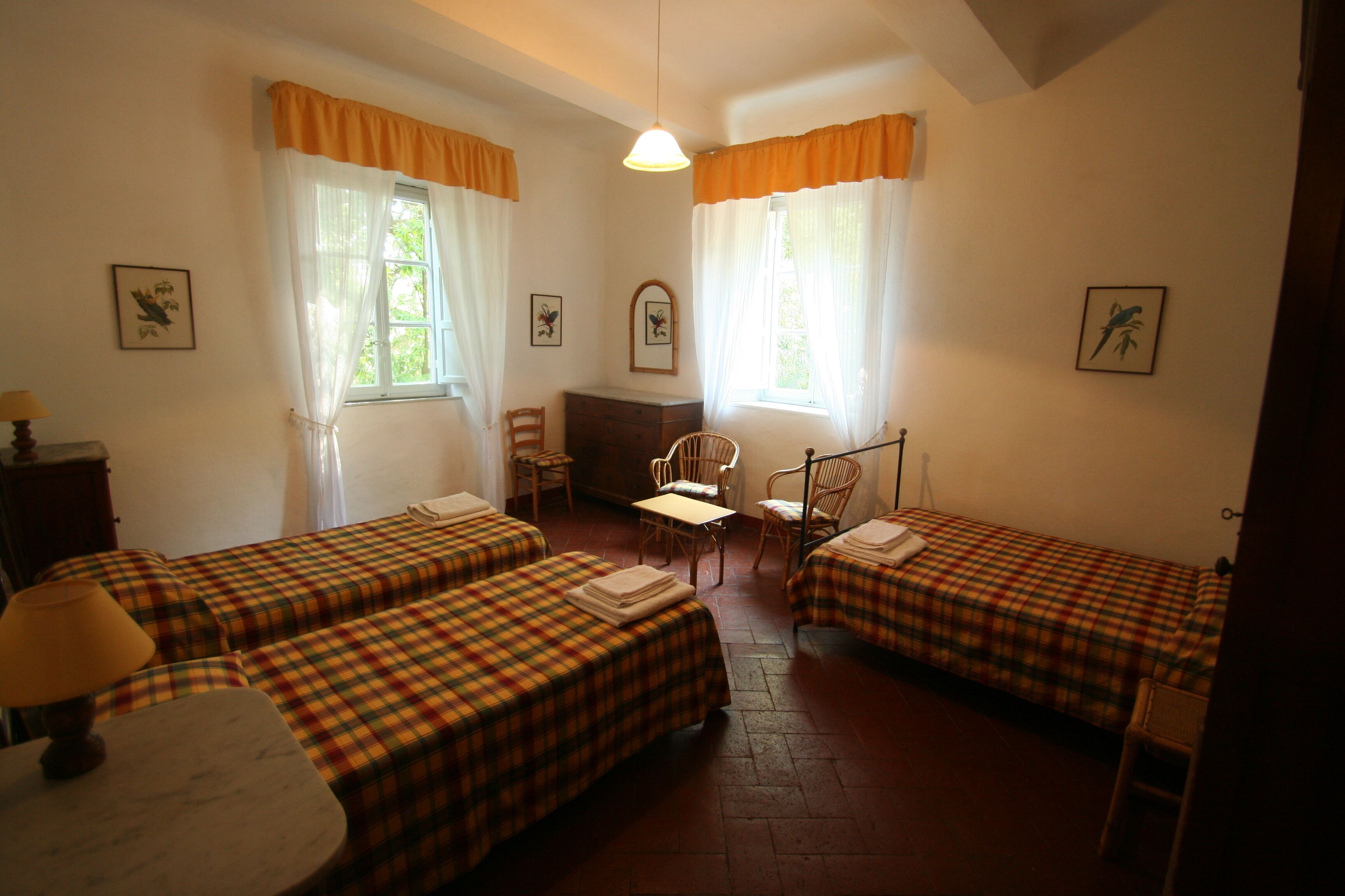 Una habitación con dos camas, un escritorio y una silla.