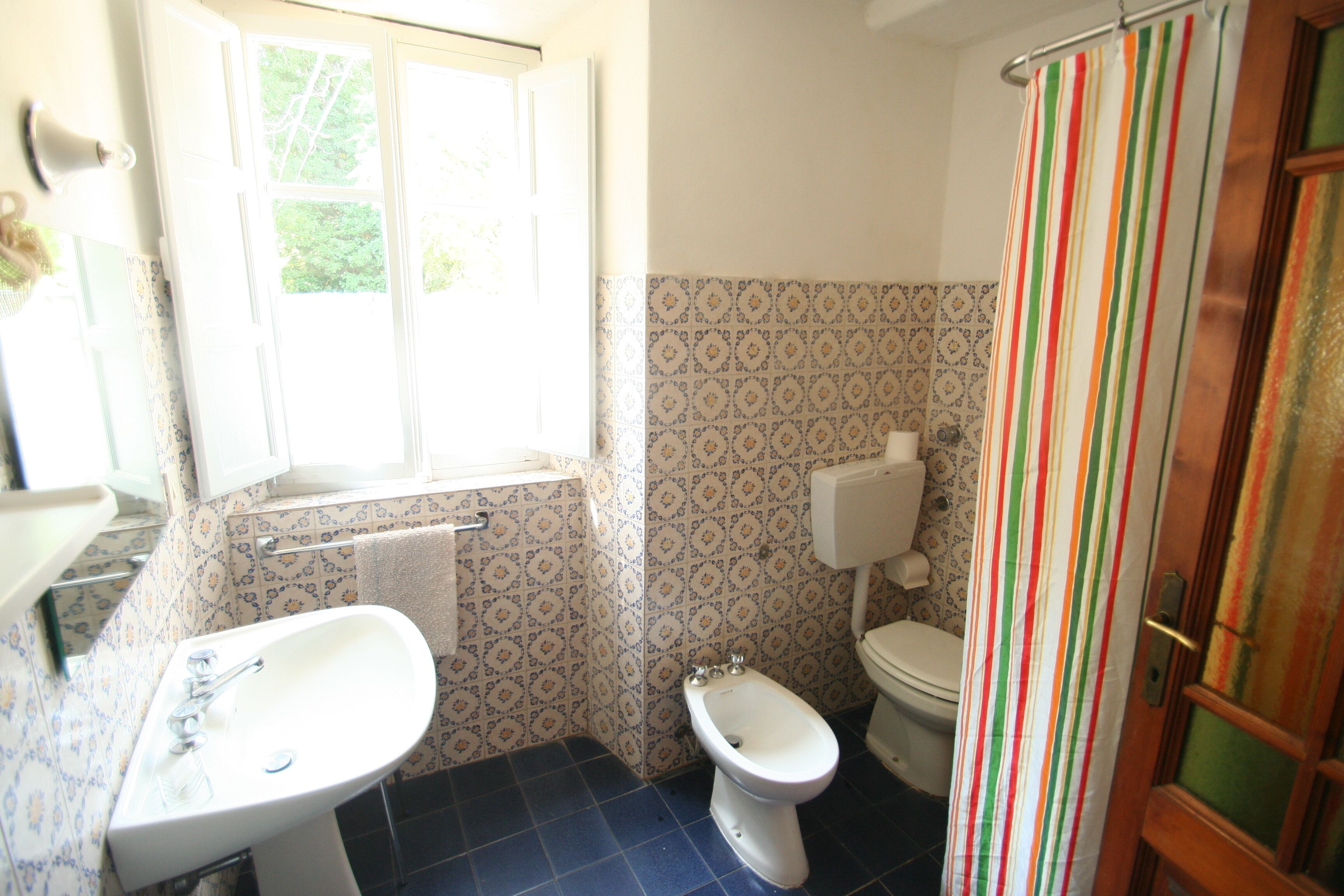 Un baño con lavamanos, inodoro y cortina de ducha.