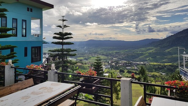 Un edificio azul con balcón que da a un valle.