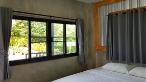 Un dormitorio con una cama grande, una ventana con cortinas y vistas al exterior.
