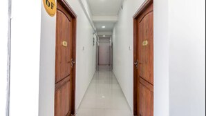A corridor with wooden doors, a sign indicating room number 6F, and a clean tiled floor. - Metro Port City Hotel (Colombo)