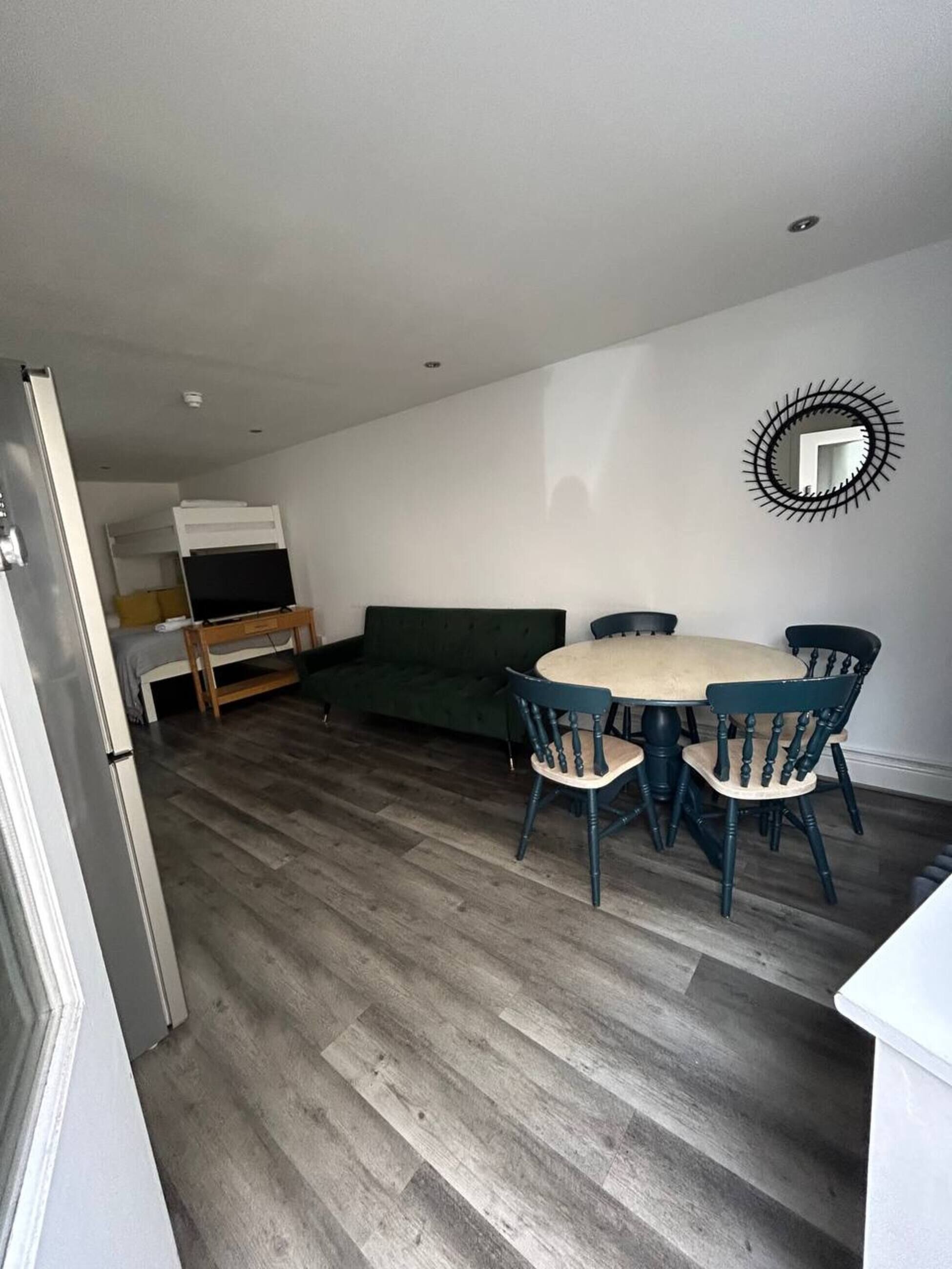 A compact living space with a dining area, a sofa, and a TV.
