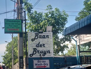 A sign for a rental service with contact numbers and a wash-dry facility. - Baan der Bruyn (Pattaya)
