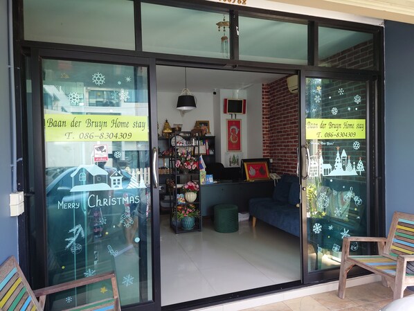 A modern home with a glass door, a contact number, and festive decorations. - Baan der Bruyn (Pattaya)