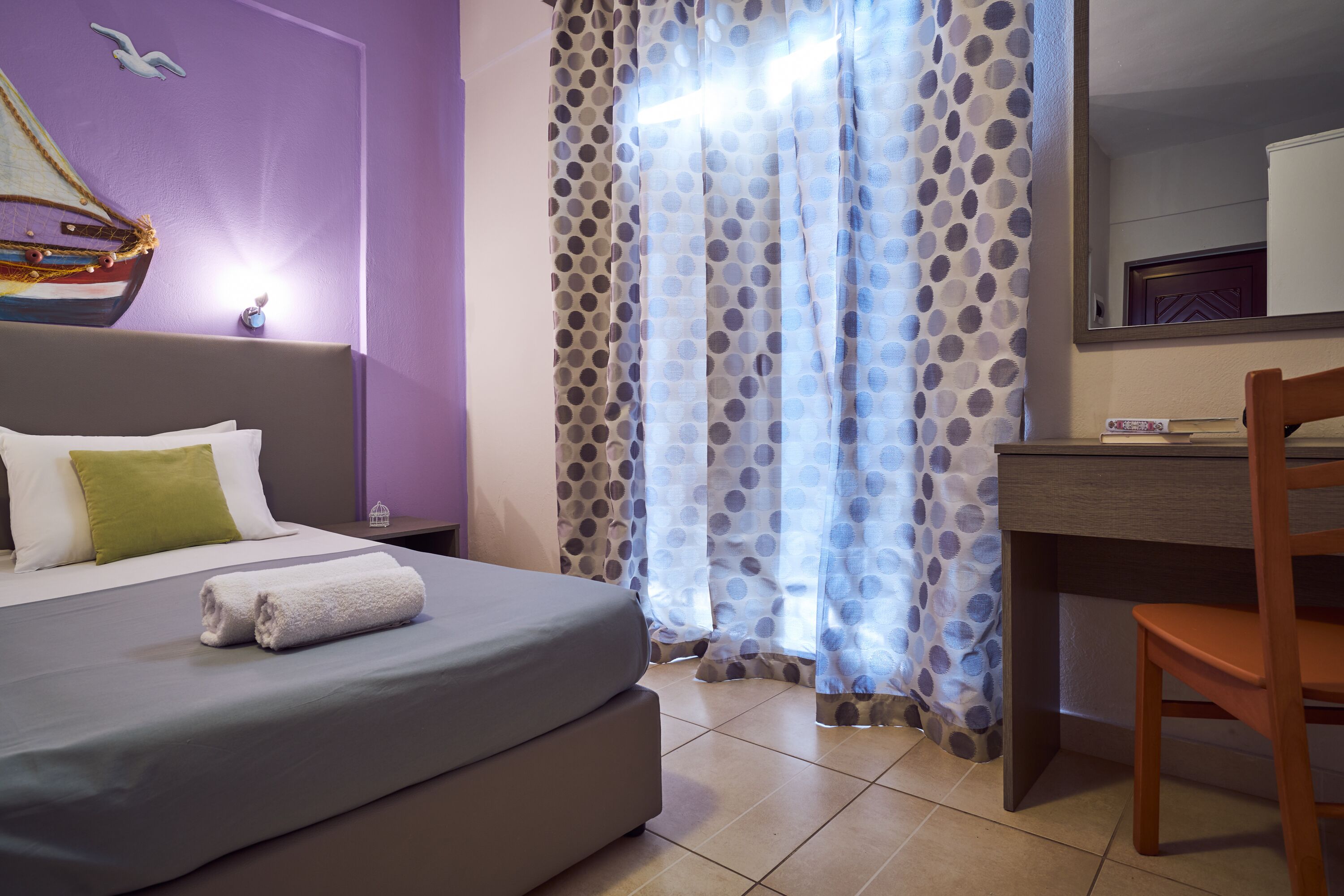 Una habitación de hotel con una cama, un escritorio y una silla.