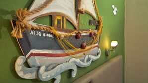 A decorative sailboat with ropes and a light fixture on a green wall. - Elena Studios (Zakynthos)