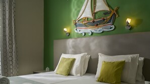 A hotel room with a bed, pillows, a wall-mounted ship decoration, and wall sconces. - Elena Studios (Zakynthos)