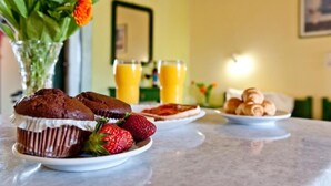 A breakfast setting with muffins, strawberries, croissants, and orange juice on a table. - Elena Studios (Zakynthos)