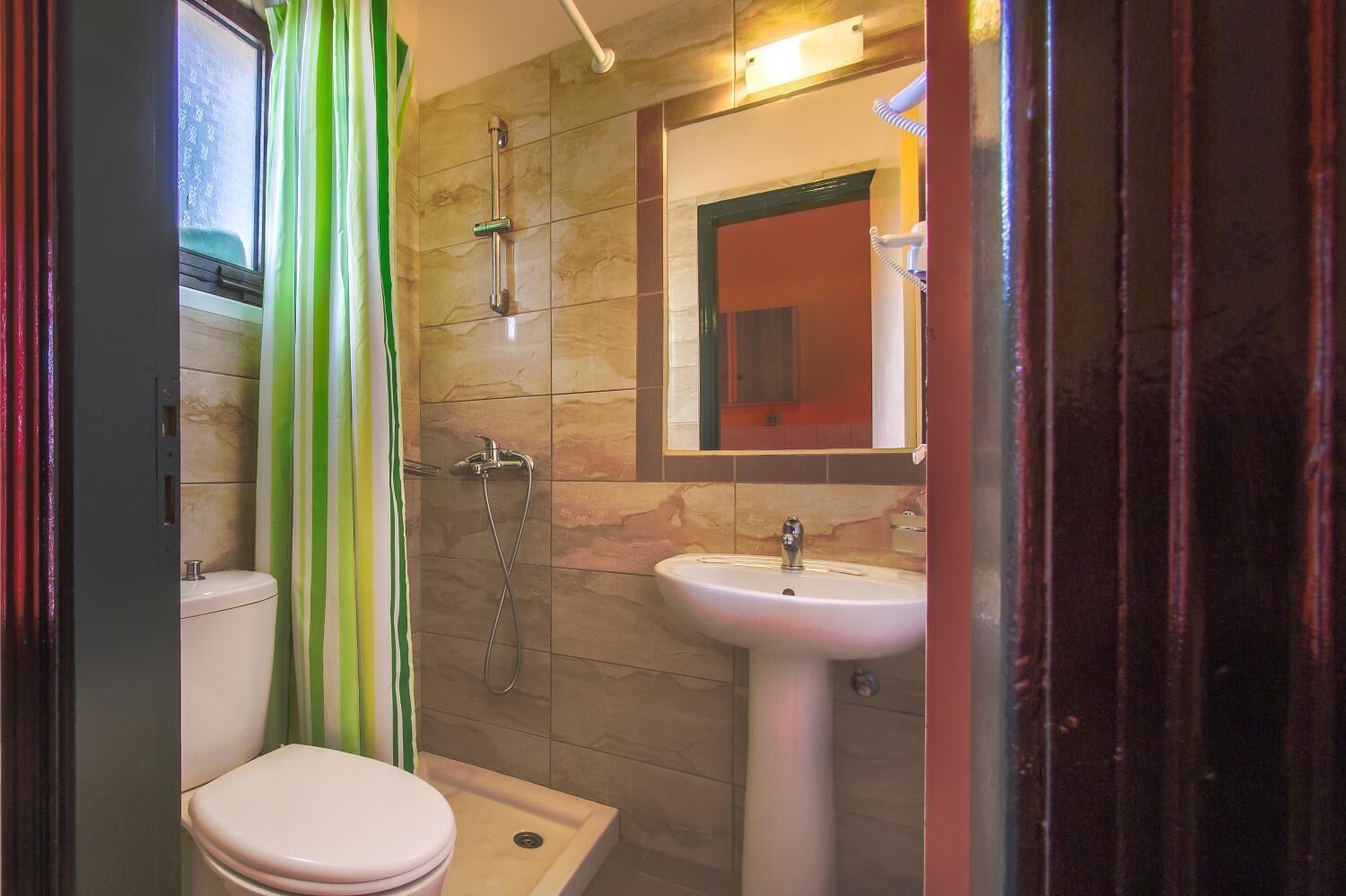 A bathroom with a toilet, a shower, and a sink.