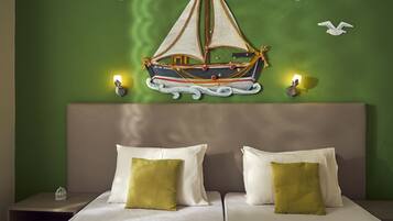Una habitación con cama, dos almohadas, un adorno náutico en la pared y dos apliques.