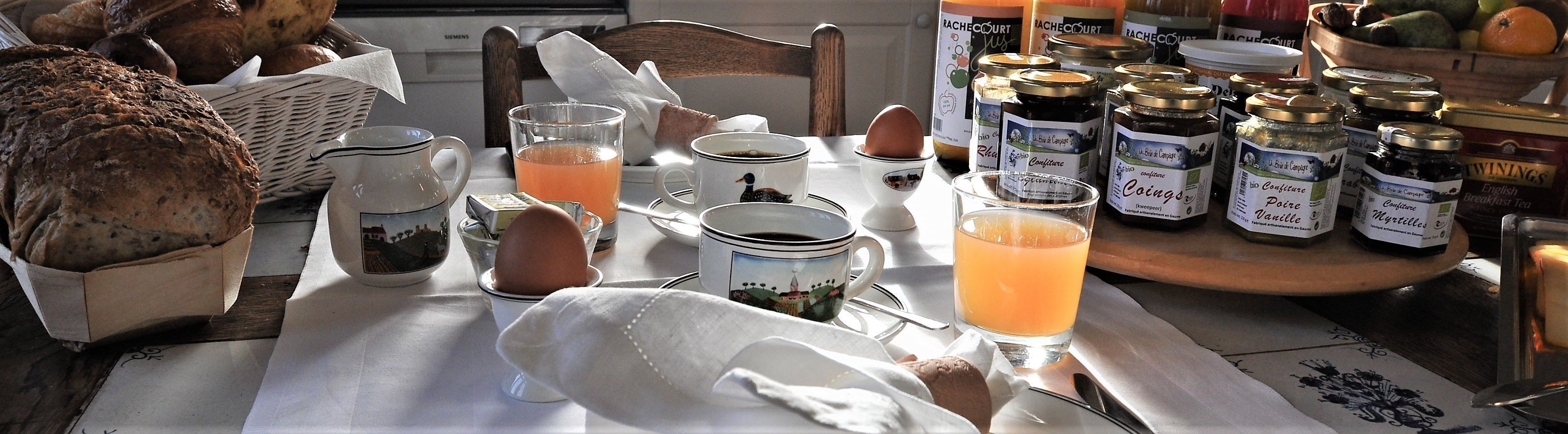 Une table de petit-déjeuner avec du pain, des œufs et divers condiments.