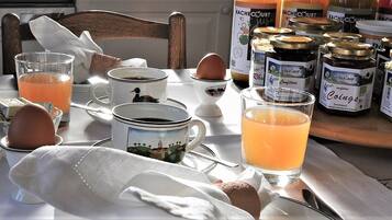 Une table de petit-déjeuner avec du pain, des œufs et divers condiments.