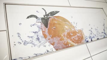 Un piso de baldosas con un charco de agua y una fruta.