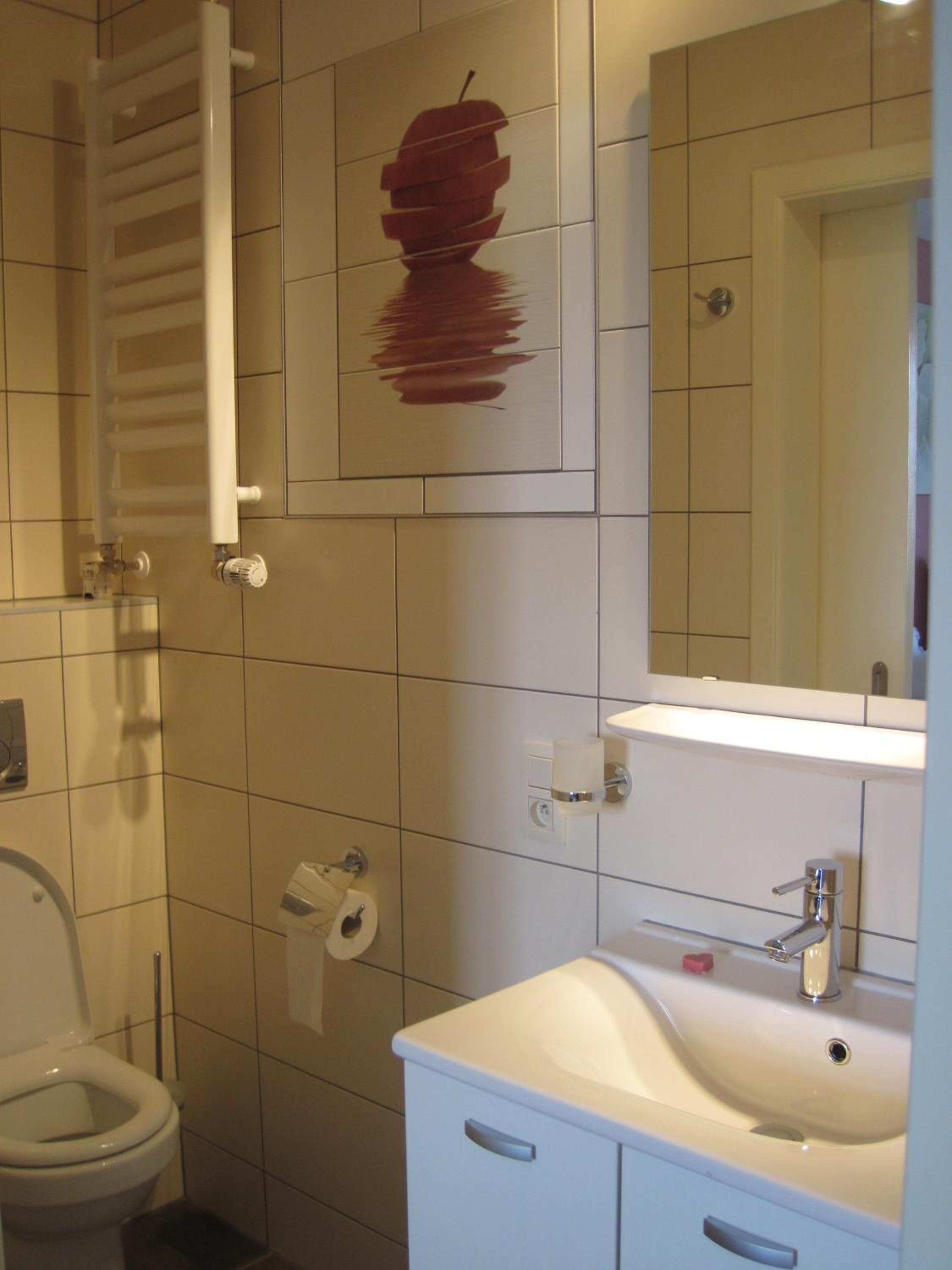 A bathroom with a toilet, sink, and towel rack.