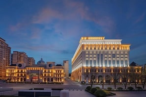 Un grand bâtiment à plusieurs étages, doté d’une façade symétrique, de grandes fenêtres et d’un dôme central.