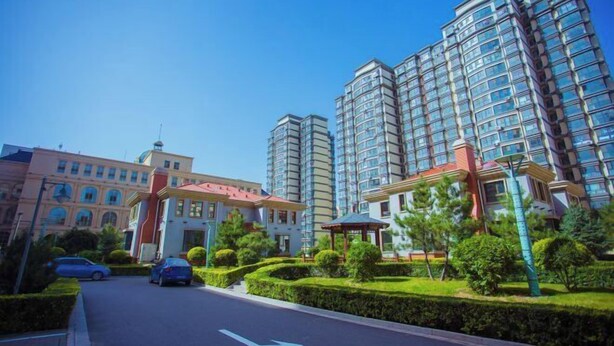 A modern residential building with multiple high-rise apartments, a central courtyard with a gazebo, and a well-maintained road. - Zhangjiakou International Hotel (Building B ) (Zhangjiakou)