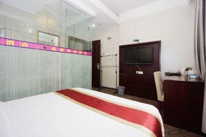 A hotel room with a bed, a TV, a desk, and a shower area. - Jingxin Business Hotel (Xishan Road Branch) (Guilin)
