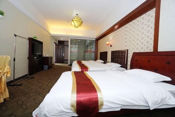 A hotel room with two beds, a television, a desk, and a mirror. - Jingxin Business Hotel (Xishan Road Branch) (Guilin)