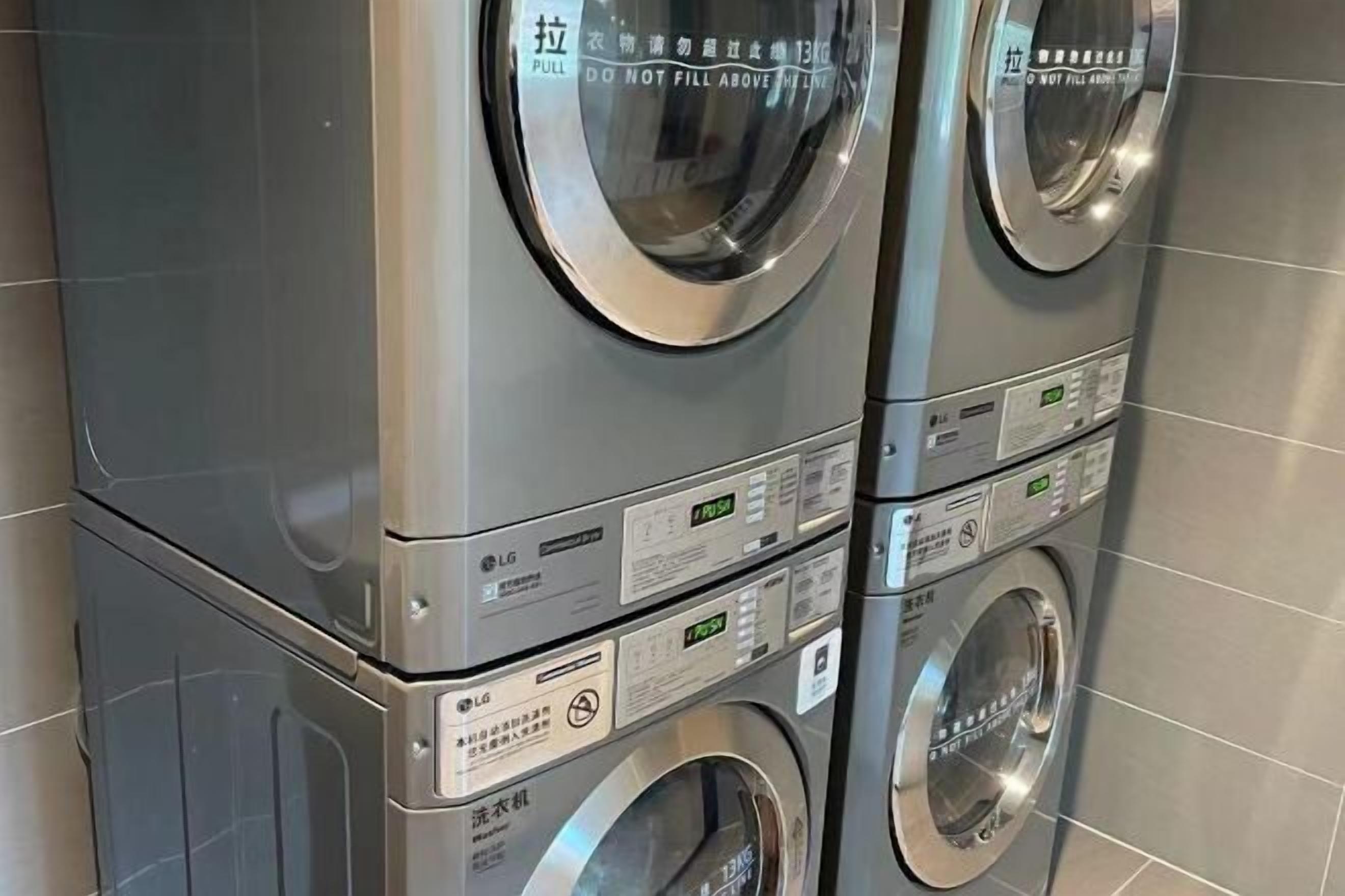 A stack of LG washing machines with visible control panels and safety warnings.