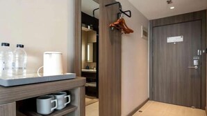 A modern bathroom with a wooden vanity, a towel rack, and a door with a sign.