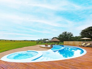 A swimming pool with a wooden deck and lounge chairs. - One Nature Nyaruswiga Serengeti (Serengeti)