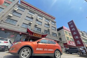 A multi-story building with a traditional architectural style, featuring a red awning and signage. - Heyuan Boutique Hotel (Shaoguan High-speed Railway Station) (Shaoguan)