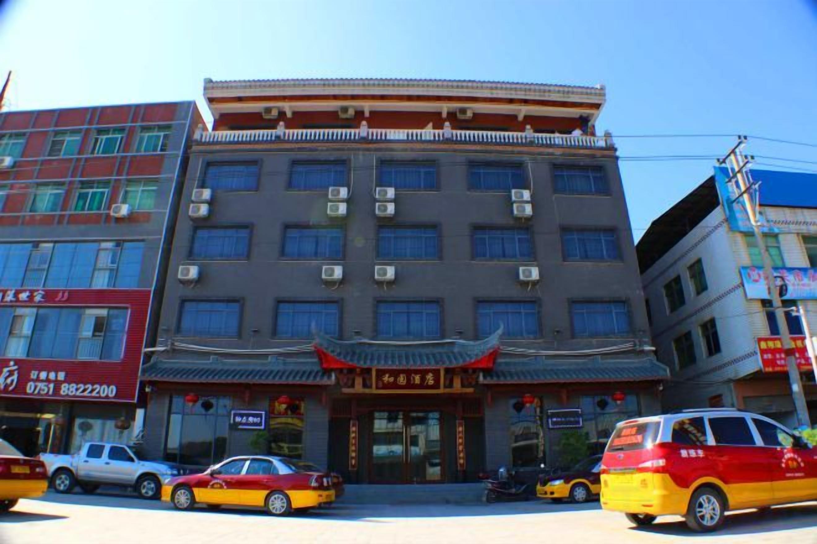 Un edificio de varios pisos con un estilo arquitectónico tradicional, que destaca por una entrada con tejado rojo y detalles decorativos.
