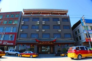 A multi-story building with a traditional architectural style, featuring a prominent entrance with a red roof and decorative elements.