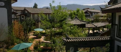 A traditional courtyard with buildings, a pathway, and umbrellas.