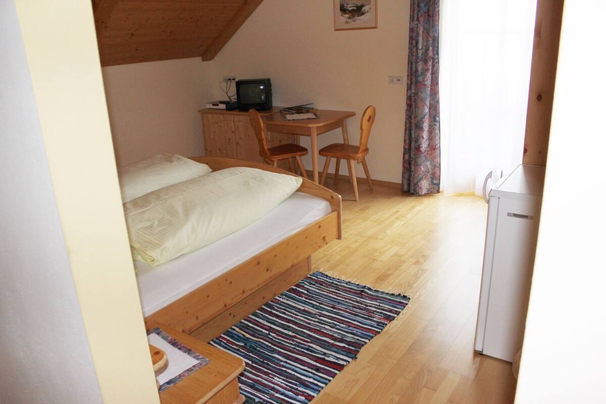 Ein Schlafzimmer mit einem Bett, einem Schreibtisch und einem Stuhl.