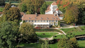 A large, historic building with a symmetrical facade, multiple windows, and a central tower.