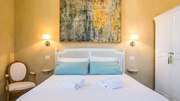 Ein Hotelzimmer mit einem großen Bett, zwei Nachttischen, einem Sessel und einem Kleiderschrank.