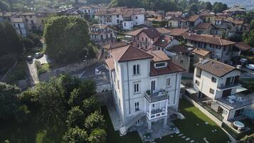 Vista aerea di una zona residenziale con diverse case a due piani, un cortile centrale e vegetazione circostante.