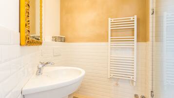 A bathroom with a white sink, a mirror with a golden frame, and a towel rack.