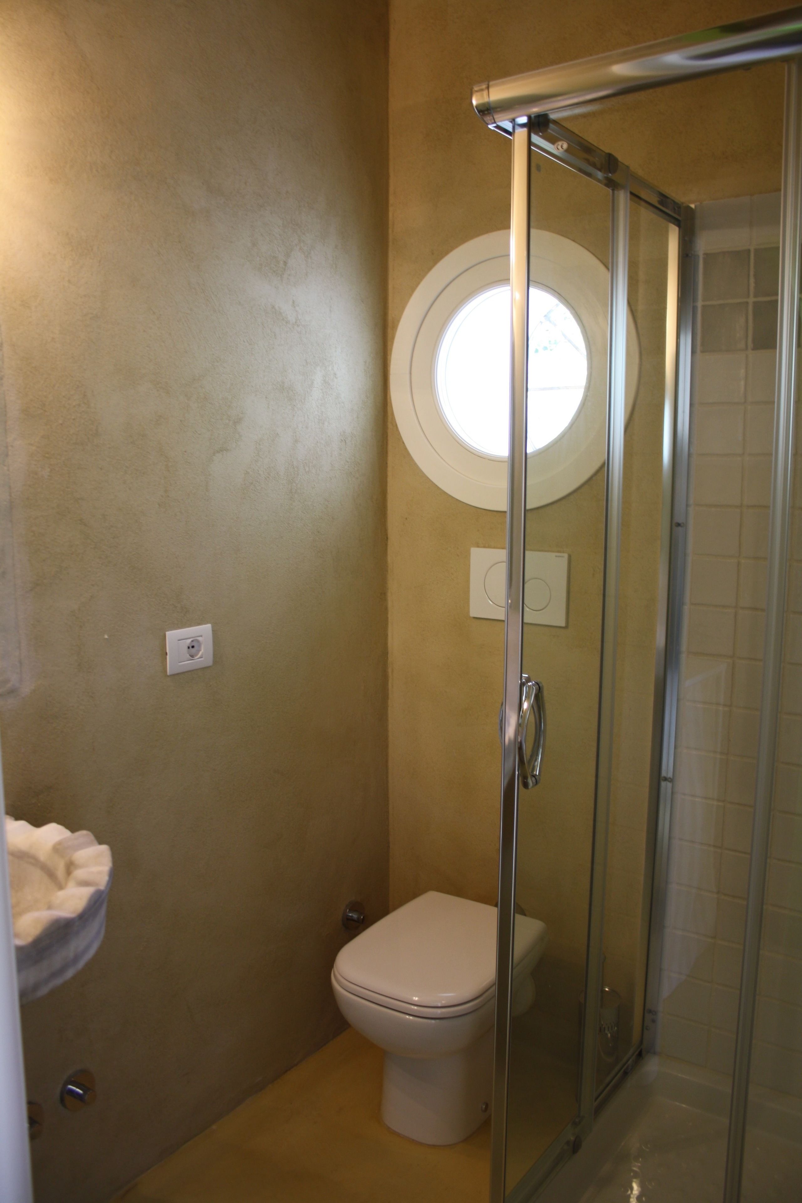 Ein Badezimmer mit Duschkabine, Toilette und Handtuchhalter.