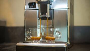 Une machine à café verse de l’expresso dans deux tasses en verre transparent.
