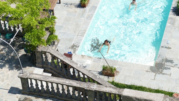 A swimming pool with a stone deck, a wooden bench, and potted plants. - White Lilac romantic B&B adults only (Arona)