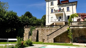 A two-story building with a stone staircase leading to a balcony. - White Lilac romantic B&B adults only (Arona)