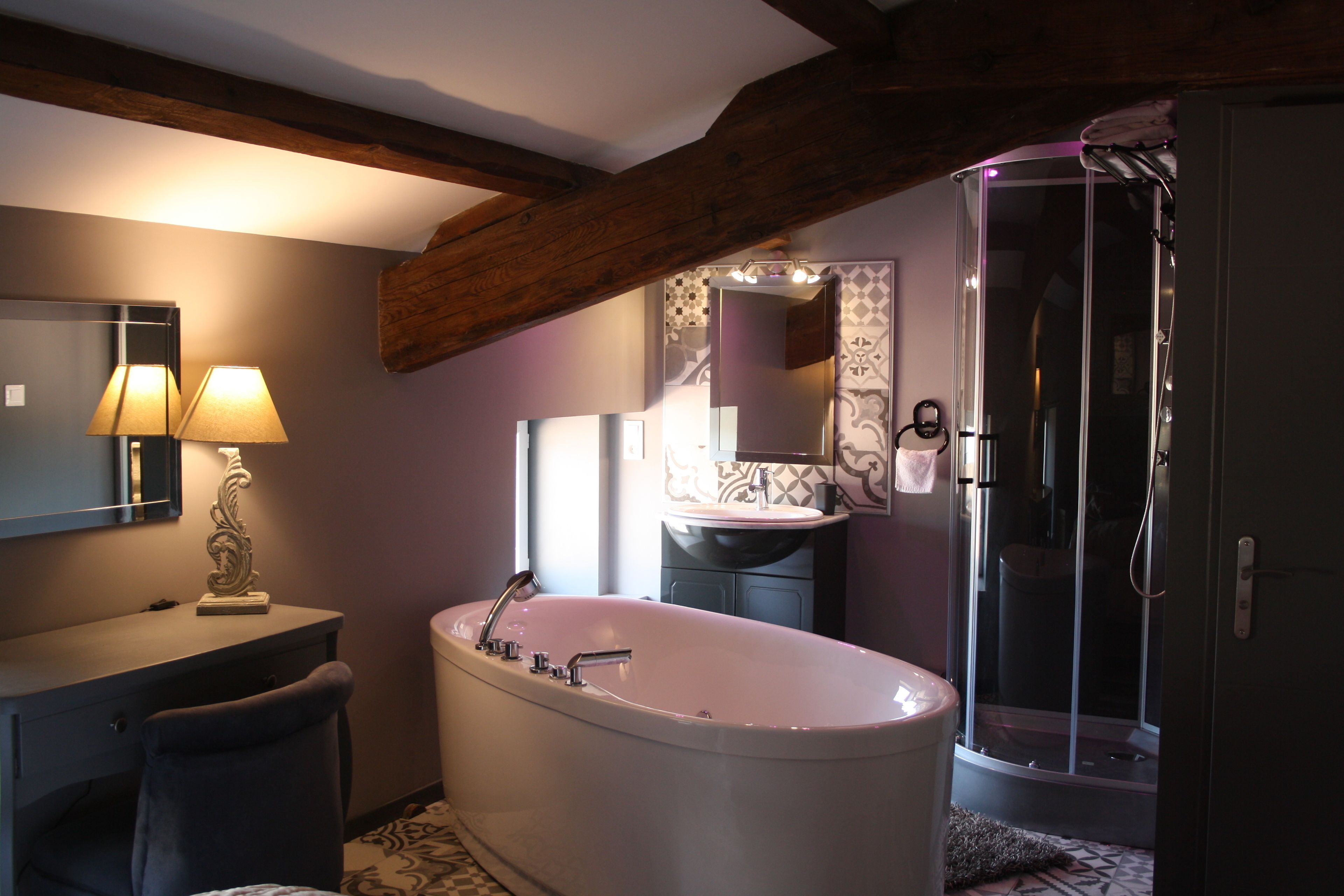 A bathroom with a freestanding bathtub, a vanity with a mirror, and a shower enclosure.