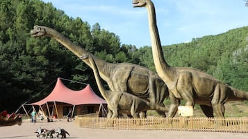 Une exposition sur les dinosaures comprenant deux grands modèles et un espace délimité par une clôture.