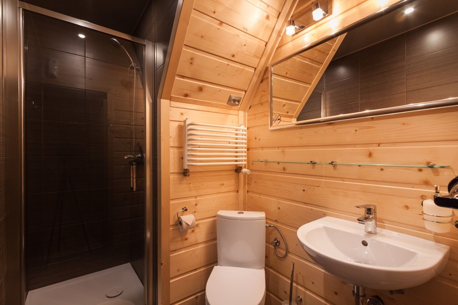 Un baño pequeño con cabina de ducha de vidrio, inodoro y lavabo.