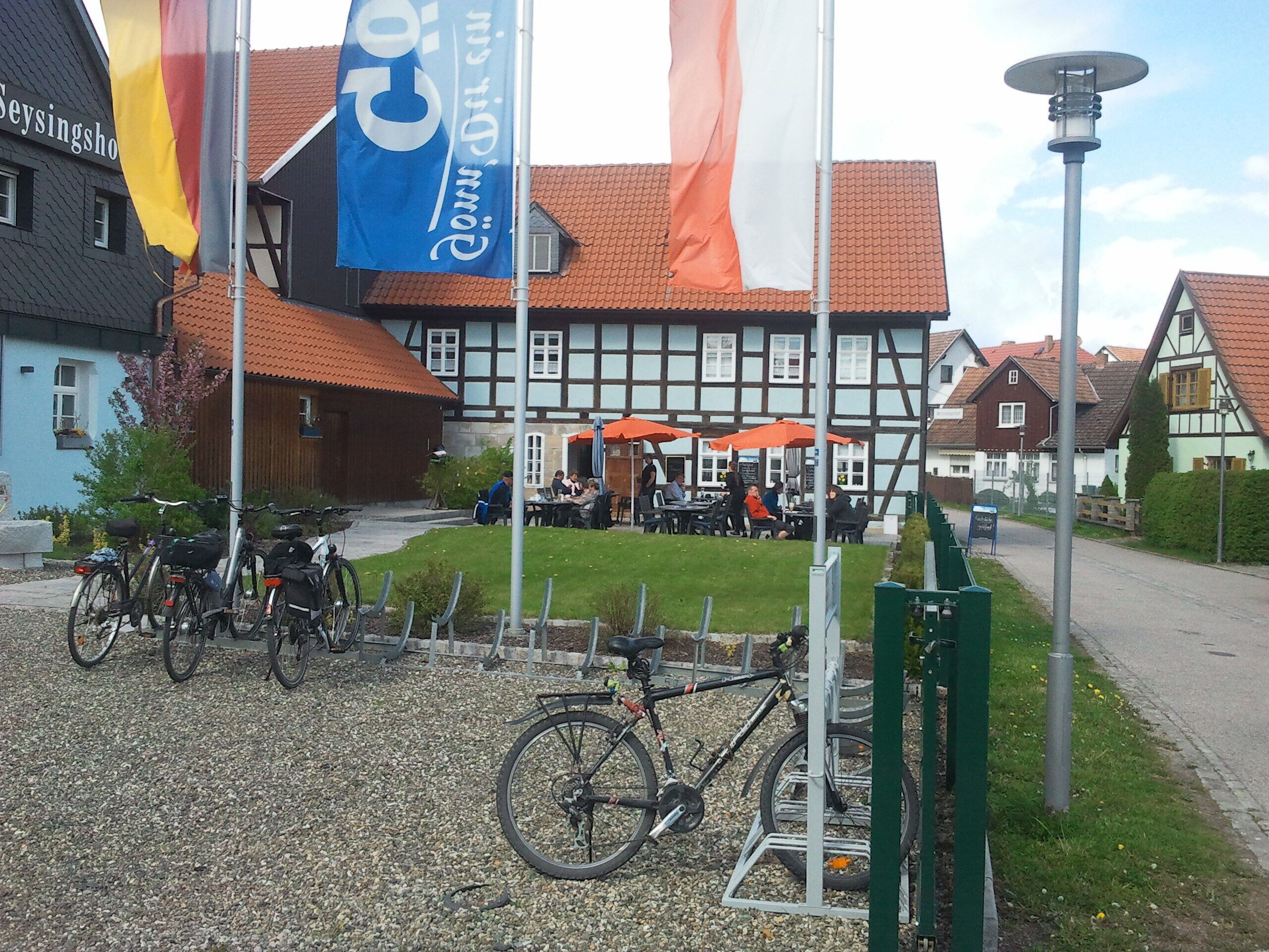 Ein traditionelles deutsches Gebäude mit Innenhof, Fahrrädern und Außenbestuhlung.