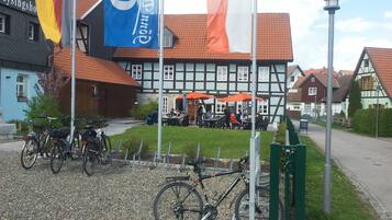 Ein traditionelles deutsches Gebäude mit Innenhof, Fahrrädern und Außenbestuhlung.