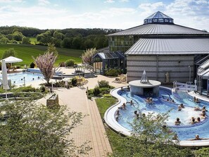 Un complexe hôtelier doté d’une grande piscine, d’espaces de détente et d’un bâtiment au design moderne.