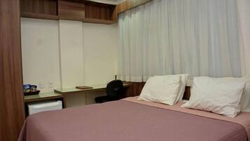 Una habitación de hotel con una cama, un escritorio y una silla.