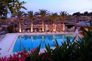 Una piscina al aire libre, sombrillas, tumbonas