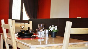 A dining table set with a wine glass, a bowl, a cup, and a flower in a pot. - Mario Apartment 5012 (Venice)