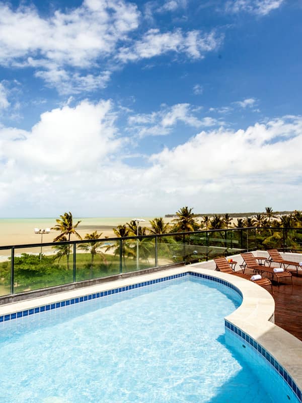 Enjoy a refreshing swim with a view of the ocean from our rooftop pool, surrounded by lounge chairs and overlooking the beach.